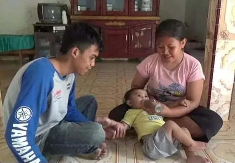 Bebê sendo alimentada com mamadeira de café pela mãe