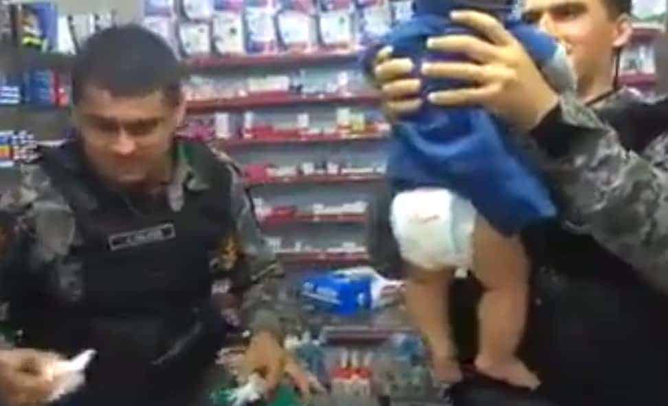 Bebê com policiais após ter tido a fralda trocada