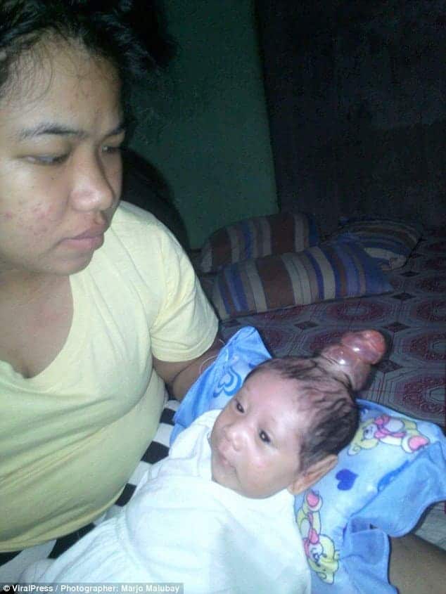 O bebê Nhel Jhon Prado no colo de sua mãe