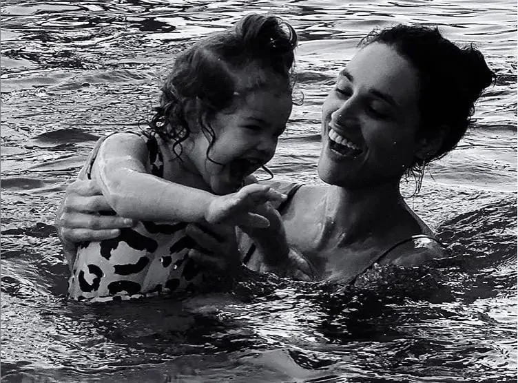 A atriz Débora Nascimento em uma brincadeira na água com sua bebê