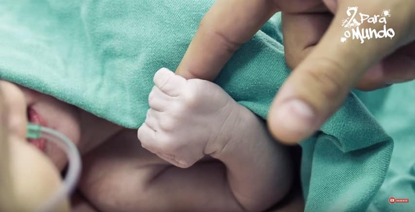 Foto do recém-nascido Luccas segurando o dedo de seu papai Fernando Medeiros