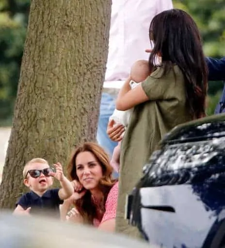 Príncipe Louis com Kate Middleton mostrando a língua para o priminho Archie no colo de Meghan Markle