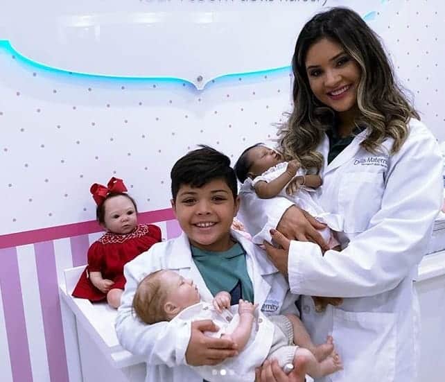 Yhudy filho do cantor Wesley Safadão com sua mãe Mileide Mihaile segurando bonecas reborn
