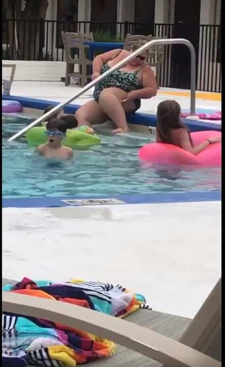 Aqui mais uma imagem da mulher fazendo sua depilação na piscina com várias crianças dentro