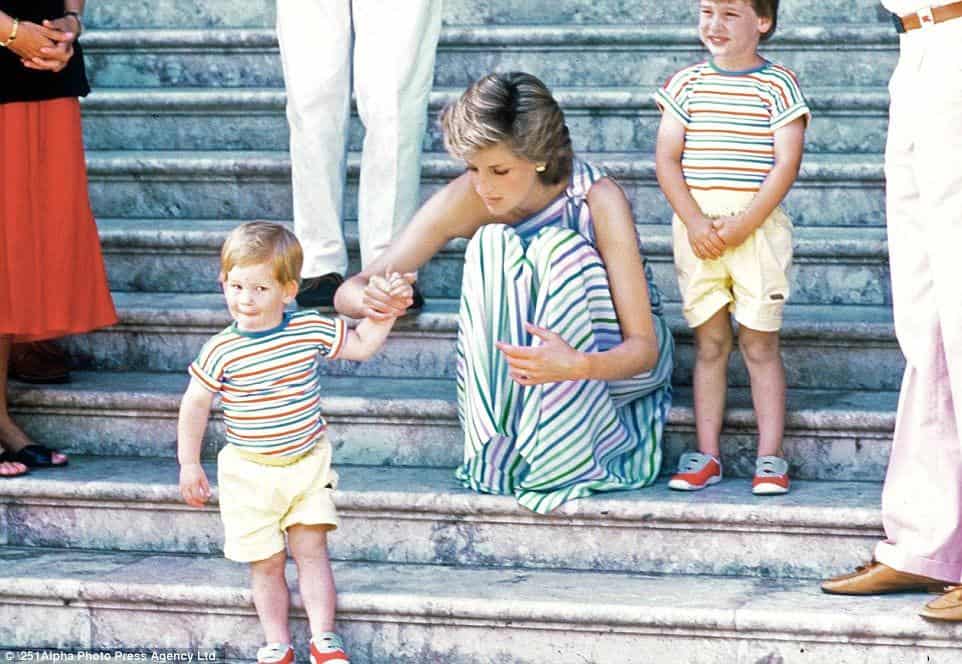 A princesa Diana agachada no momento de lidar com os filhos príncipe Harry e príncipe William