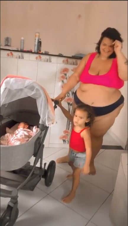 Thais Carla mostrando a barriga pós-parto com as filhas