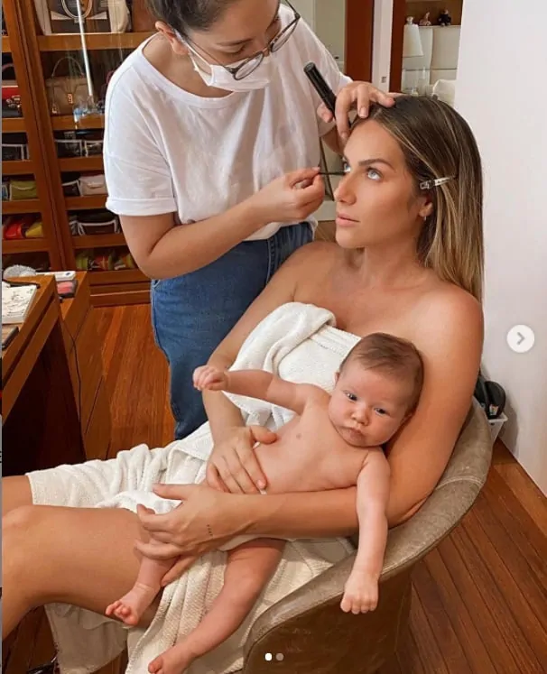 Giovanna Ewbank se maquiando com seu bebê no colo