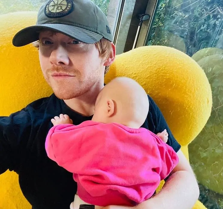 Rupert Grint com sua bebê no colo