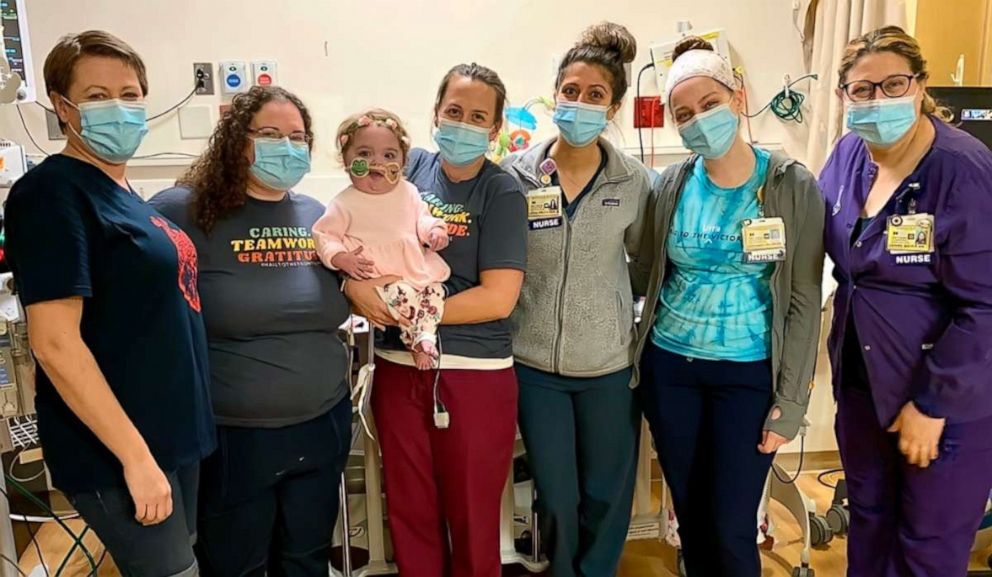 A bebê junto com as funcionárias do hospital que cuidaram dela 