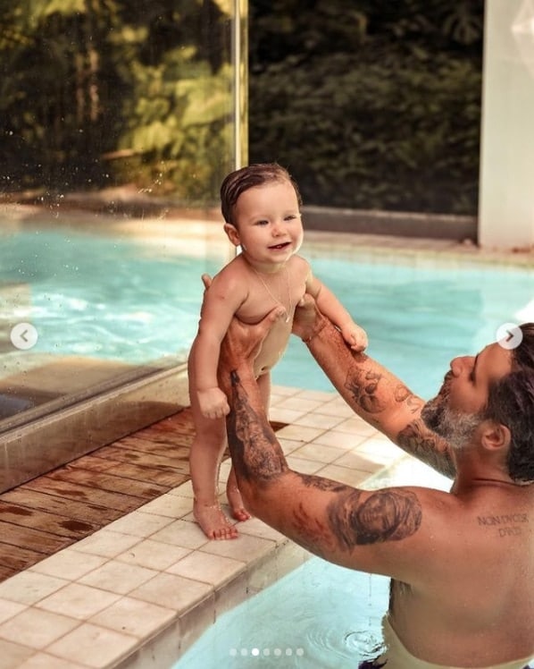 Bruno Gagliasso na piscina da sua mansão com o filho
