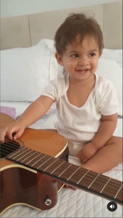 O pequeno Léo, filho de Murilo Huff e Marília Mendonça, com um violão