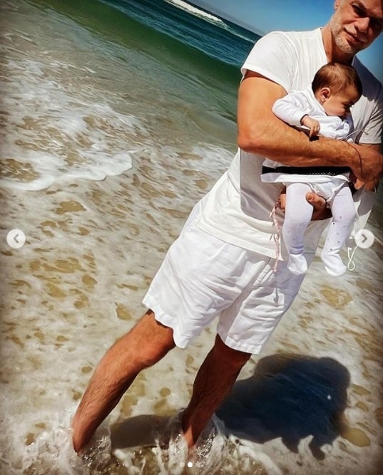 Fábio Assunção com a pequena Alana Ayó na praia