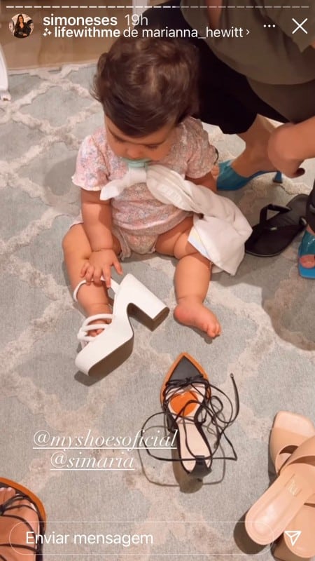 A pequena Zaya, bebê de Simone, tentando usar um sapato de Simaria