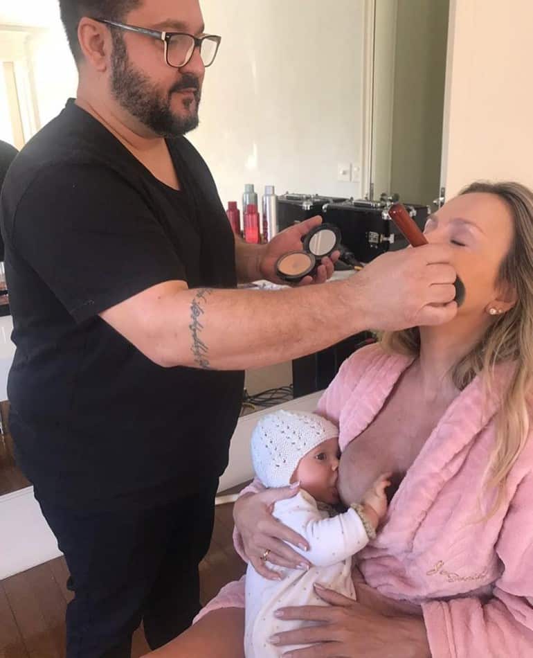 A apresentadora Eliana sendo maquiada e amamentando a filha, Manuela 