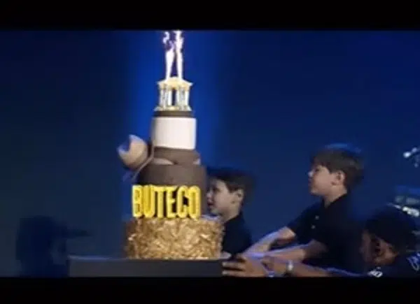 Os filhos de Andressa Suita e Gusttavo Lima levando o bolo para o cantor 