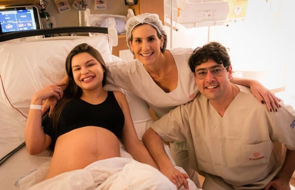 Bruno de Luca e Sthefany Vidal posam com a filha recém-nascida e a médica que fez o parto 