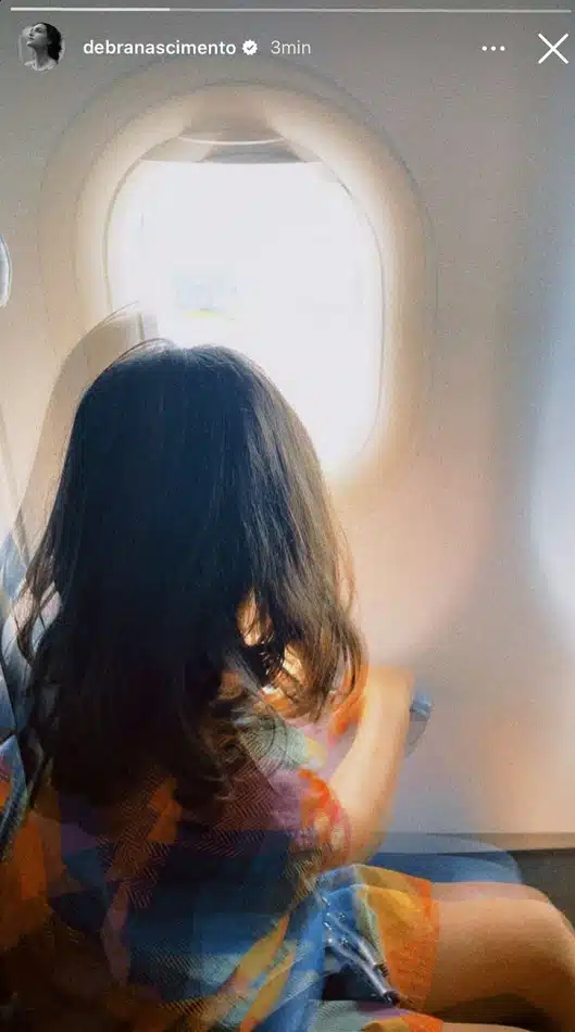 Bella, filha de Débora Nascimento e José Loreto, observando a paisagem em viagem de avião 