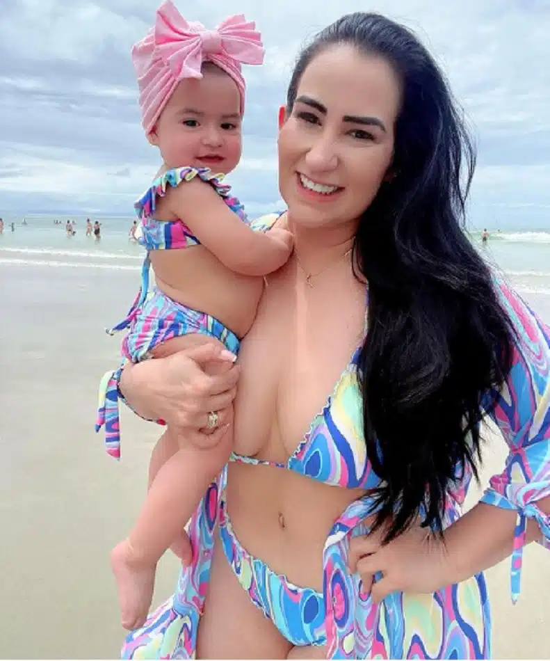 A jornalista Fabíola Gadelha com sua bebê, de 10 meses, na praia usando biquínis iguais 