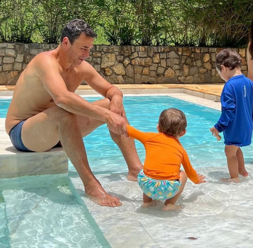 João e Pedro, filhos gêmeos dos jornalistas Andréia Sadi e André Rizek, se divertindo com o pai na piscina 