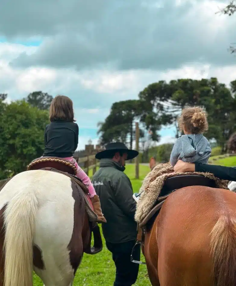 Nina, filha de Mel e Rodrigo Santoro, andando a cavalo em viagem com a mamãe 