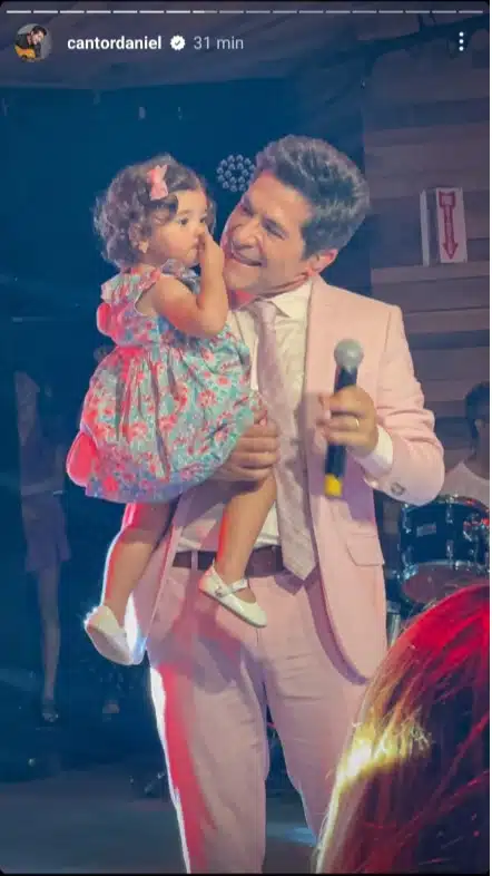 Daniel posa com sua filha caçula no palco nos EUA