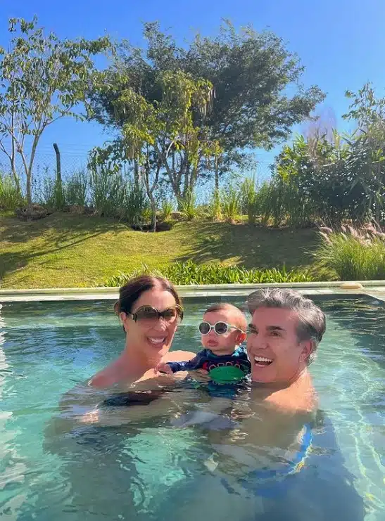 Claudia Raia posa com seu filho e seu marido  na piscina da mansão 
