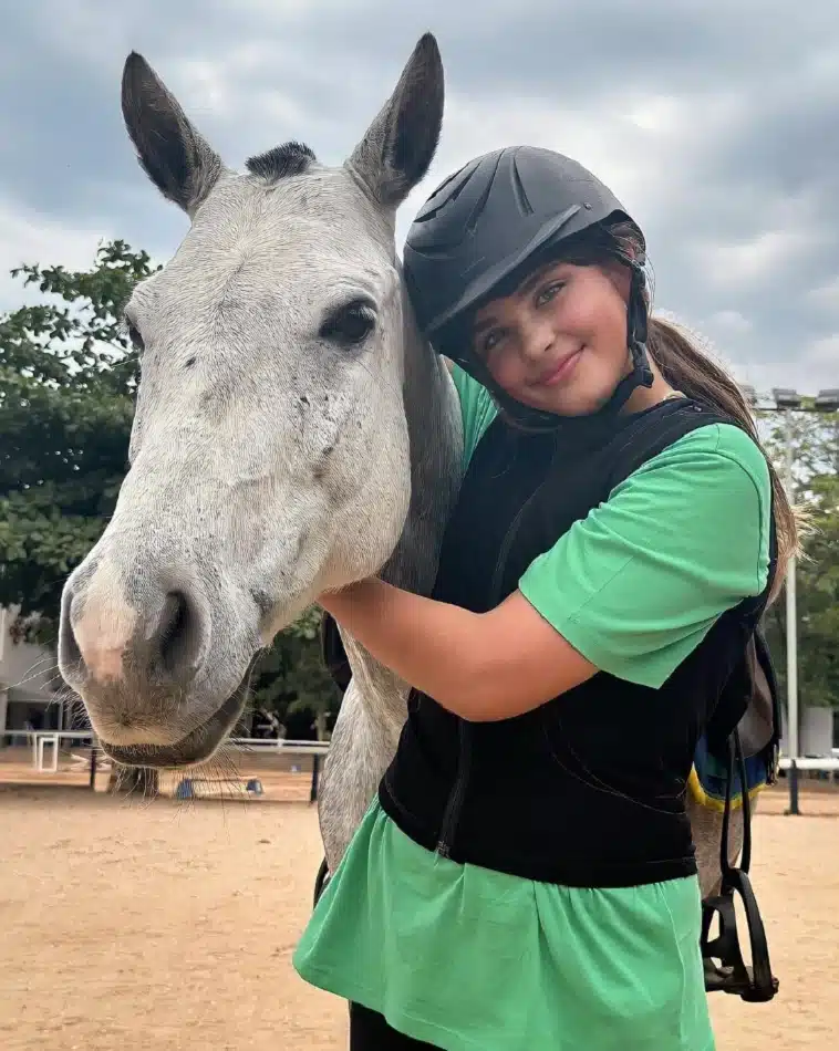 Sofia, filha de Grazi Massafera e Cauã Reymond, com um dos cavalos da aula 