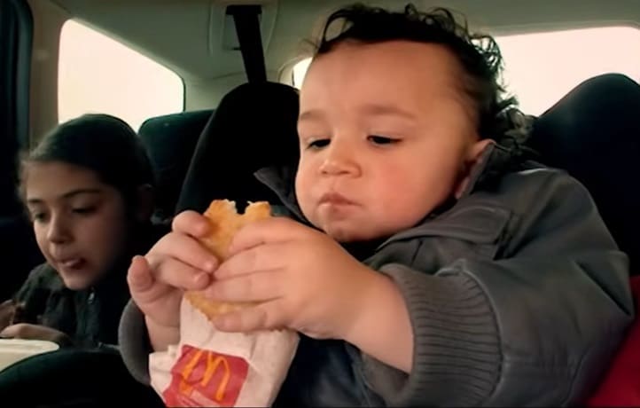 Bebê comendo hambúrguer antes de mudar a alimentação da família