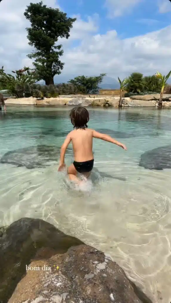 Giovanna Ewbank mostrando seu filho caçula em um lago