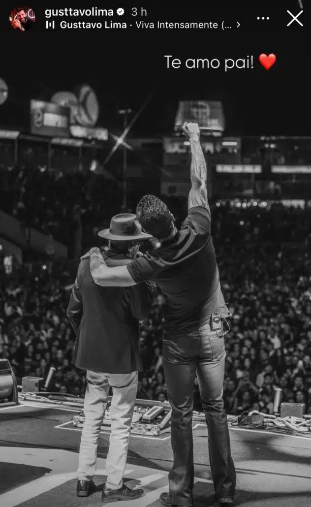 Gustavo Lima stands with his father on stage.