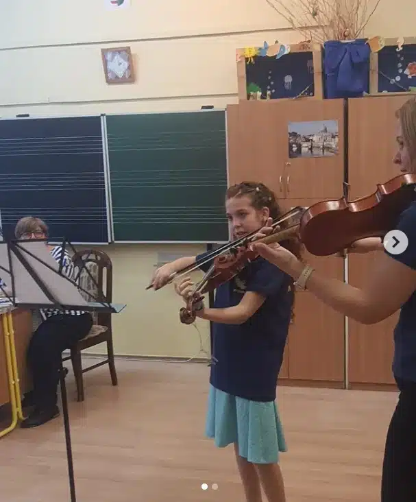 Gabriella Gaspar exibindo sua filha em aula de violino