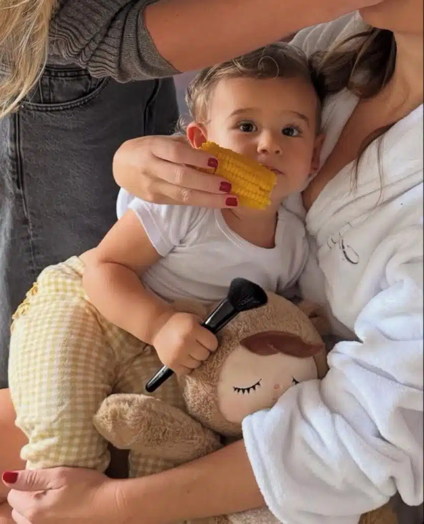 A atriz Fernanda Paes Leme mostra a filha saboreando um milho, enquanto ela se arruma
