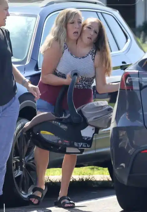 Gêmeas siamesas levando o filho para sua escola