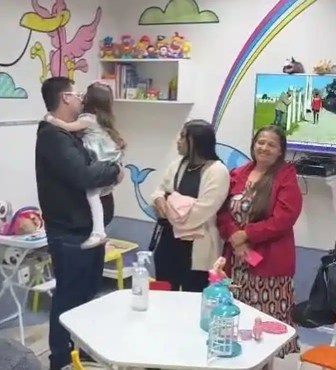 A menina ao lado de seu pai e avó paterna