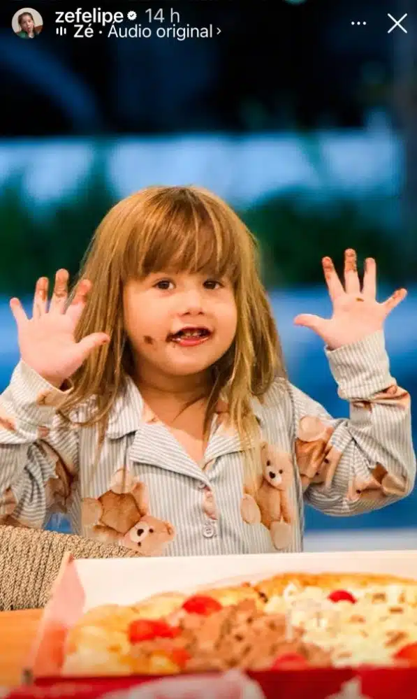 Maria Alice, primogênita de Virgínia e Zé Felipe, comendo pizza