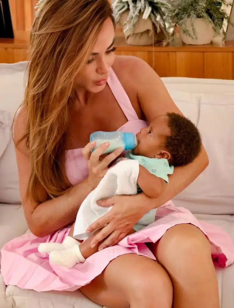 Nicole Bahls surge cuidando de um bebê em casa