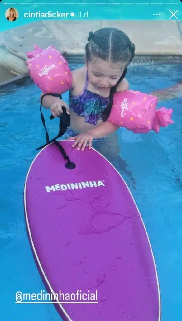 Aurora, filha mais nova de Pedro Scooby, com sua prancha do Gabriel Medina