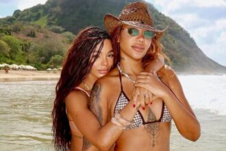 Brunna e Ludmilla posam com a filha na praia com biquínis combinando