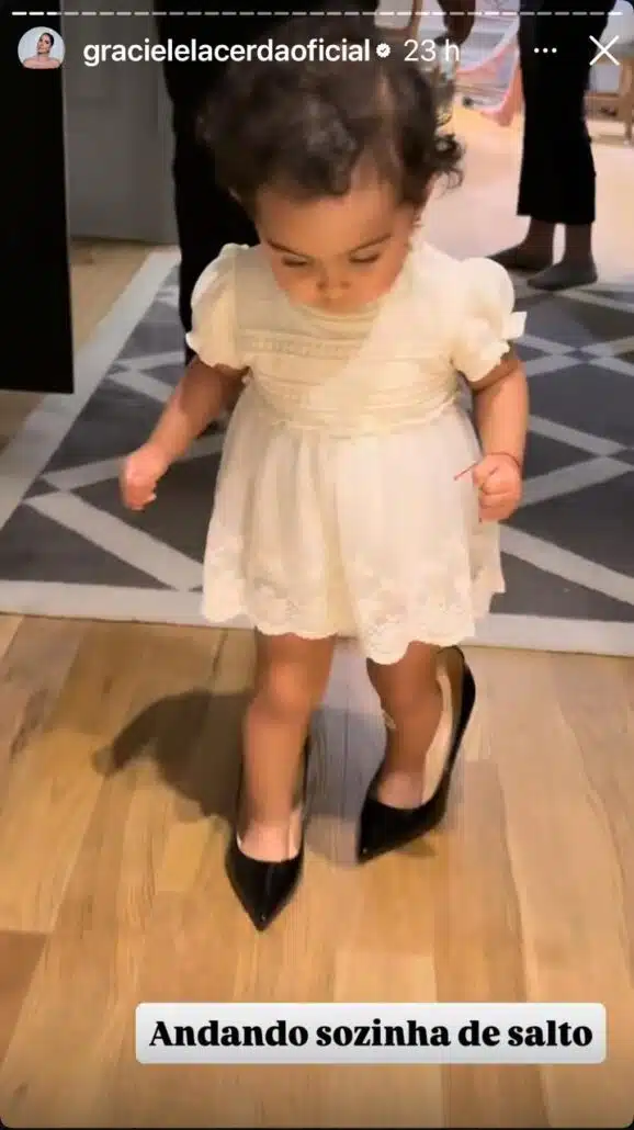 Clara, filha de Graciele Lacerda, andando com um salto
