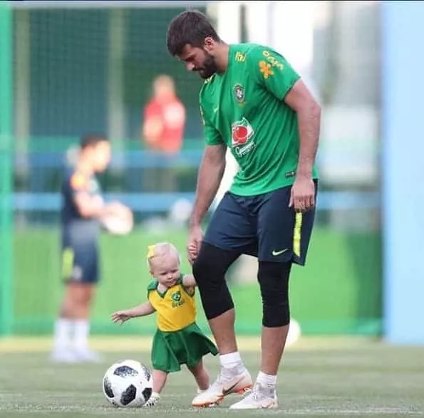A pequena Helena com o papai Alisson no treino da Seleção Brasileira