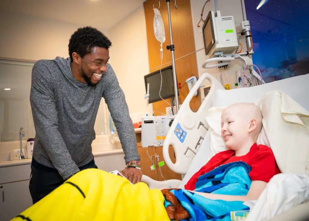 Chadwick Boseman visitando criança com câncer