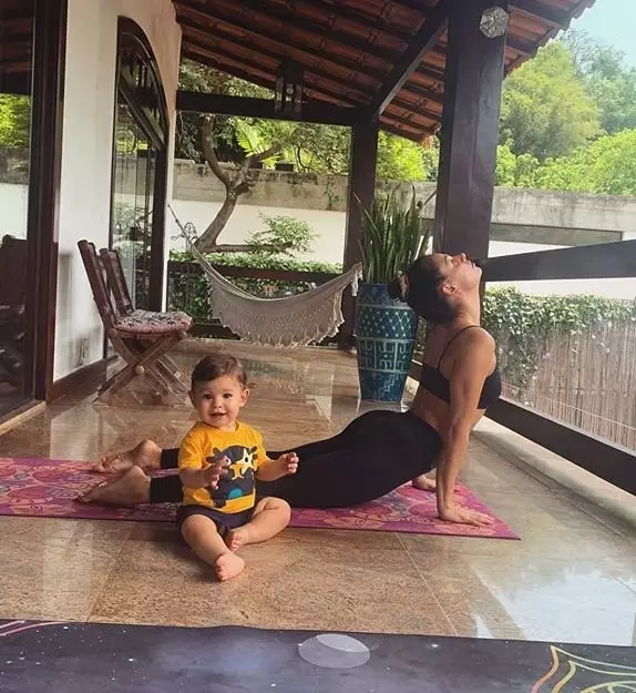 Isis Valverde praticando ioga ao lado do filho