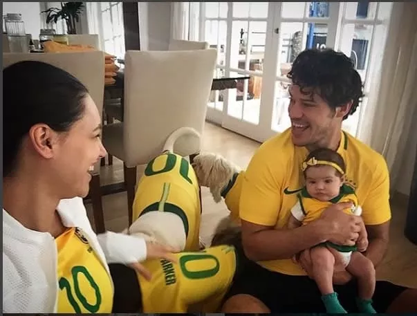 A fofíssima Bella no colo do José Loreto e junto da mamãe Débora Nascimento, torcendo pelo Brasil