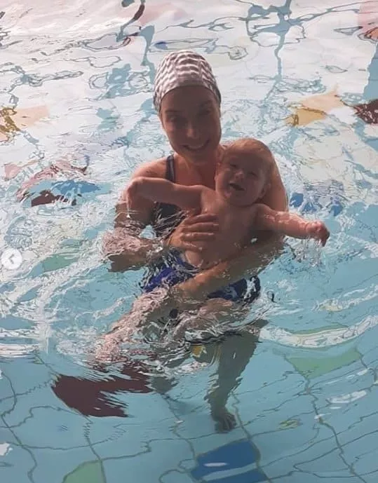 Cantora com seu bebê na aula de natação