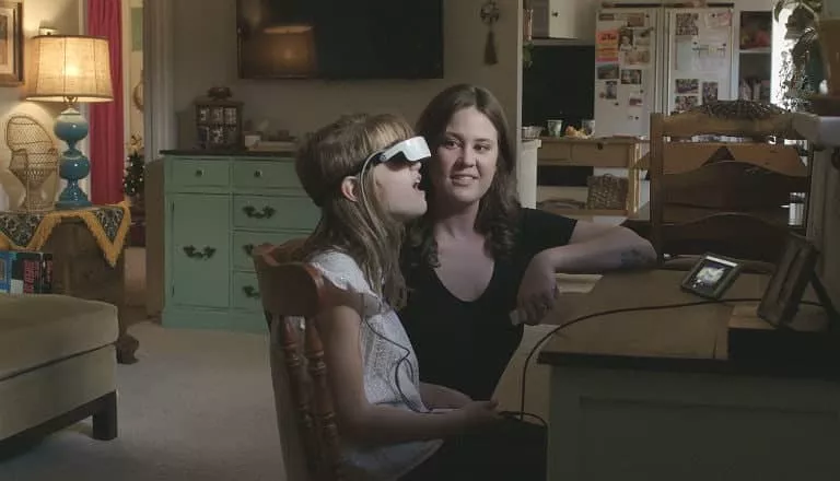 Menina usa óculos especiais para o computador