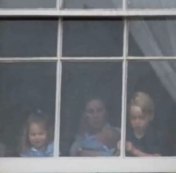 Os príncipes Louis, George e Charlotte na janela do castelo