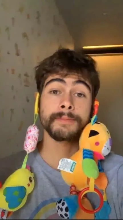 Rafael Vitti com brinquedinhos nas orelhas para acalmar sua bebê