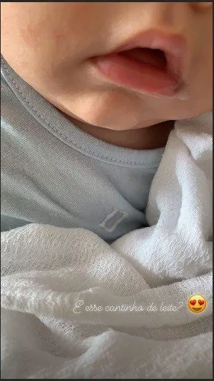O bebê Dom com a boca cheia de leite