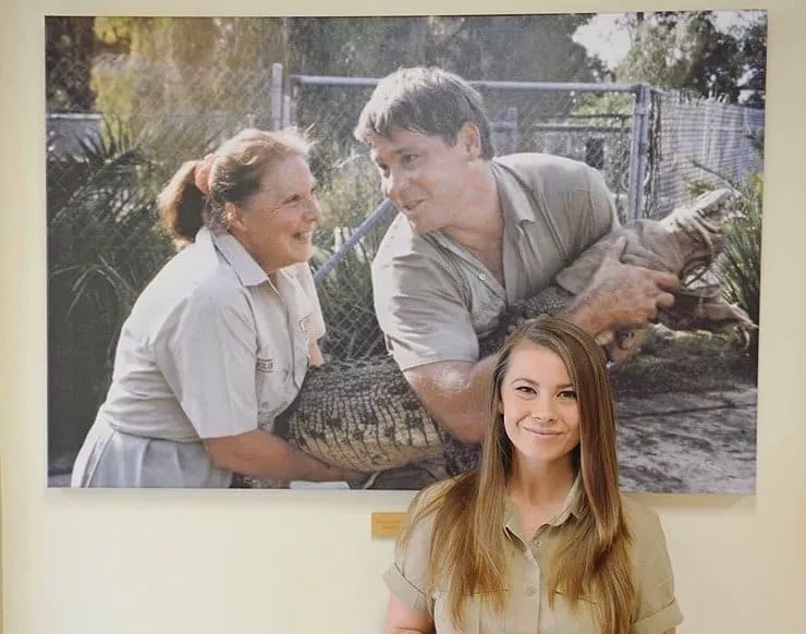 Bindi diante da foto do pai Steve Irwin e da avó