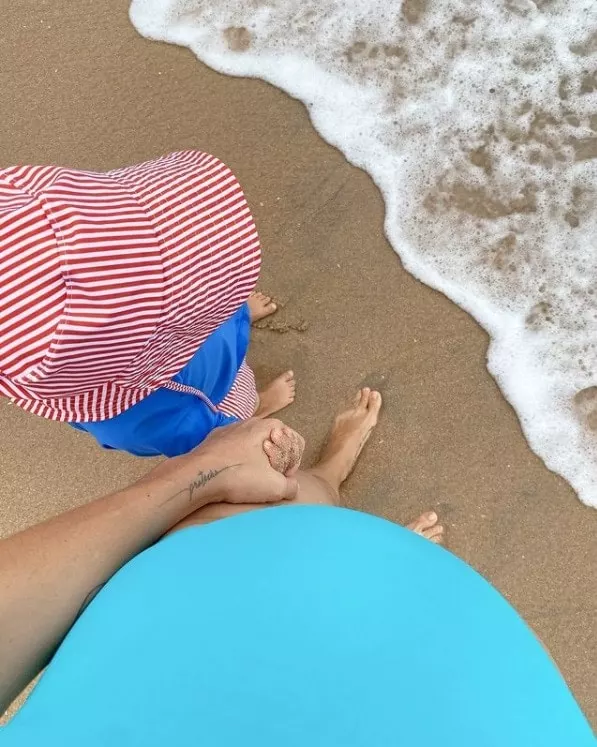 Monica Benini grávida e na praia com seu bebê com Junior Lima